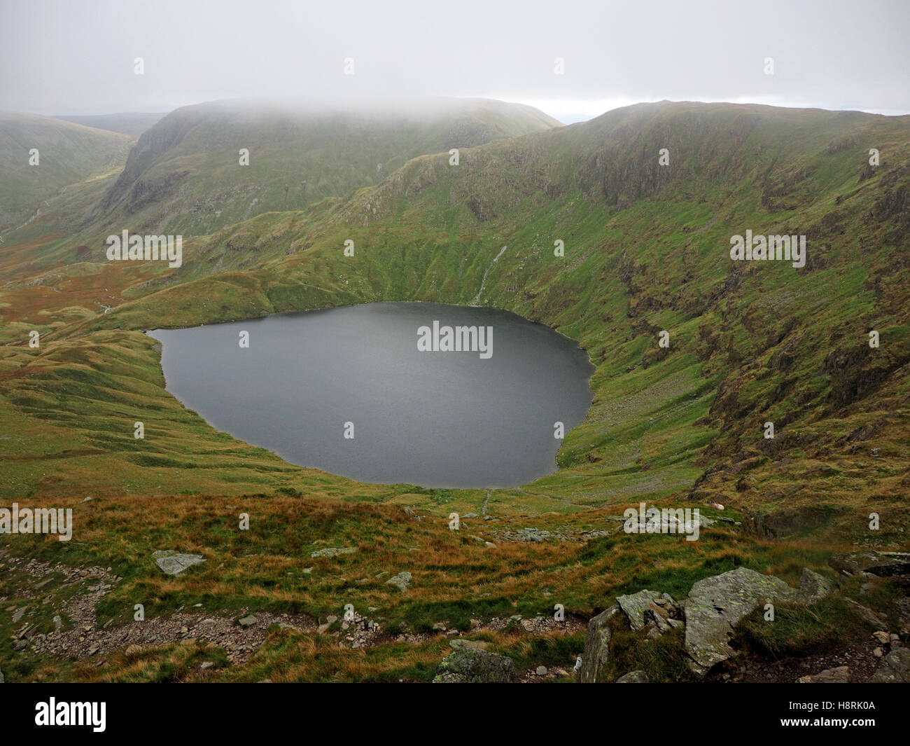 Blick über Blea Wasser in Richtung Harter fiel in Wolke von Riggindale Crag auf High Street über Haweswater Seenplatte UK Stockfoto