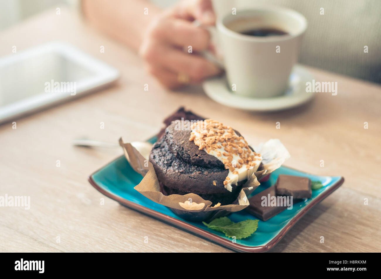Leckere Schoko-Muffin mit Schokoladenstückchen und frischen Kaffee für ...
