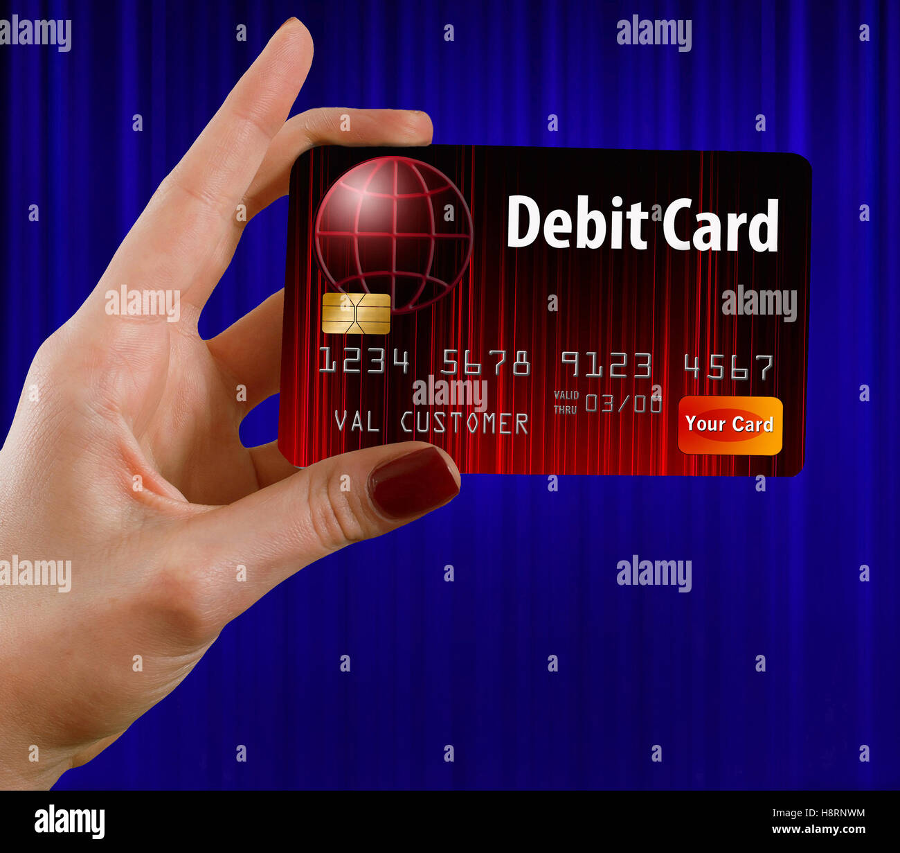Eine weibliche Hand hält eine Debit Karte das ist rot und schwarz. vor einem blauen Vorhang. Dies ist ein Foto Illustration kombinieren Foto Stockfoto