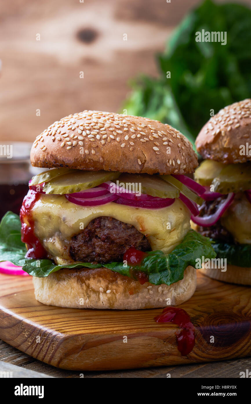 Burger mit Gurken, roten Zwiebeln und Salat Stockfoto