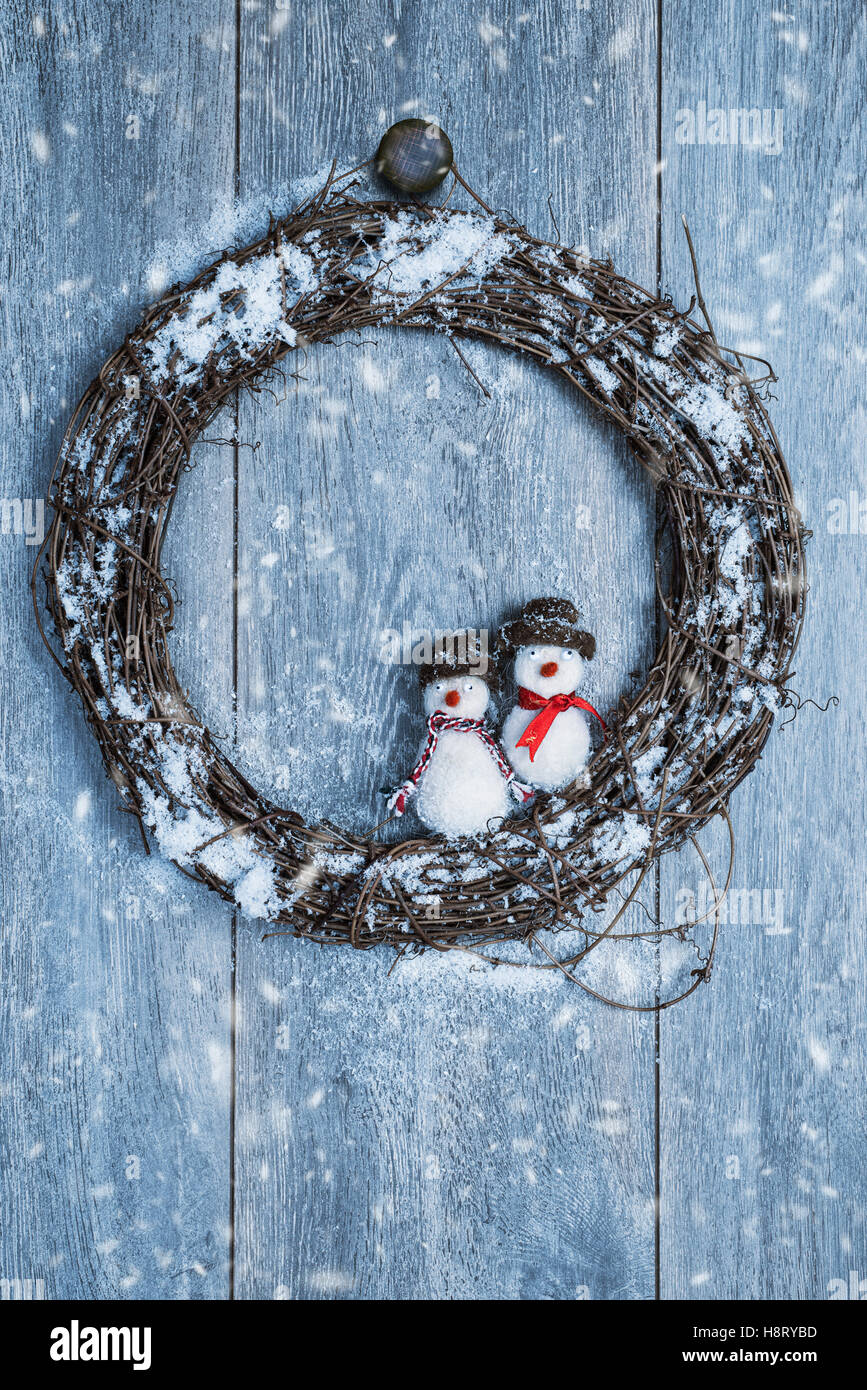 Winter-Girlande hängen rustikale Holztür mit Schneemänner Dekoration Stockfoto