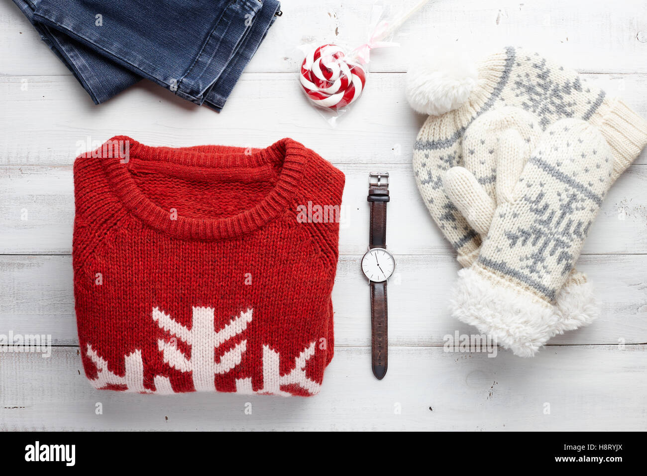Weihnachten-Kleidungsstil set mit Winter Strickpullover, Jeans, Mütze, Handschuhe, Uhren und Lutscher. Stockfoto