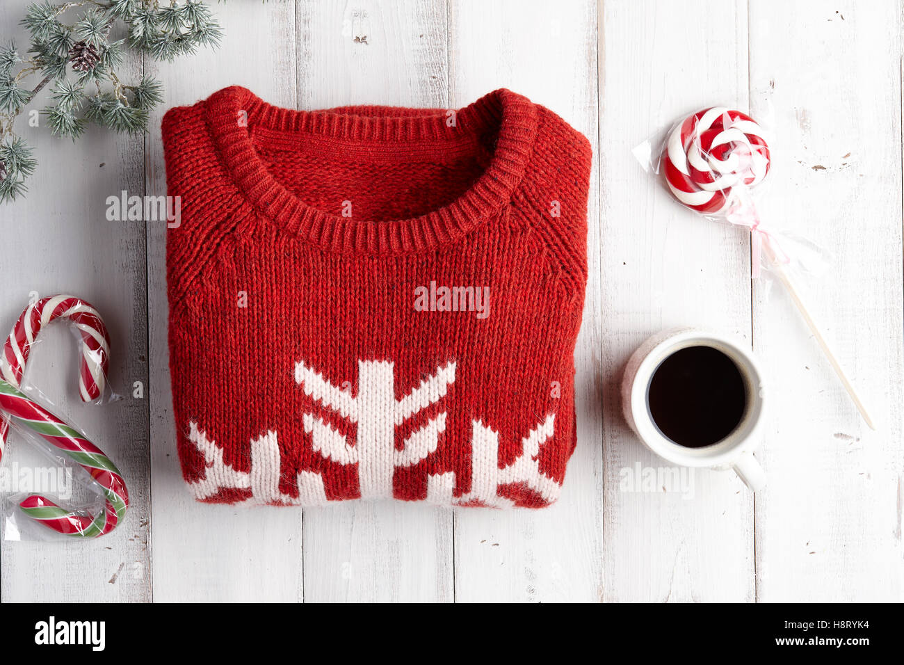 Winterurlaub, gestrickte Pullover, heißen Kaffee und Lutscher auf weißem Holz Hintergrund Stockfoto