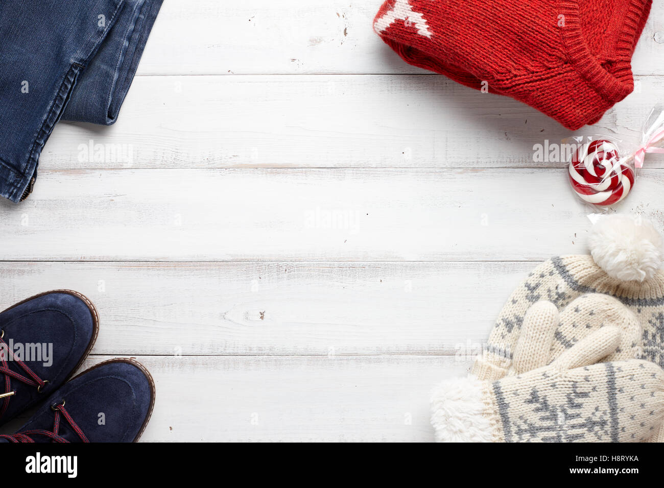 Winterurlaub, gestrickte Pullover, Handschuhe und Mütze auf weißem Holz Hintergrund Stockfoto