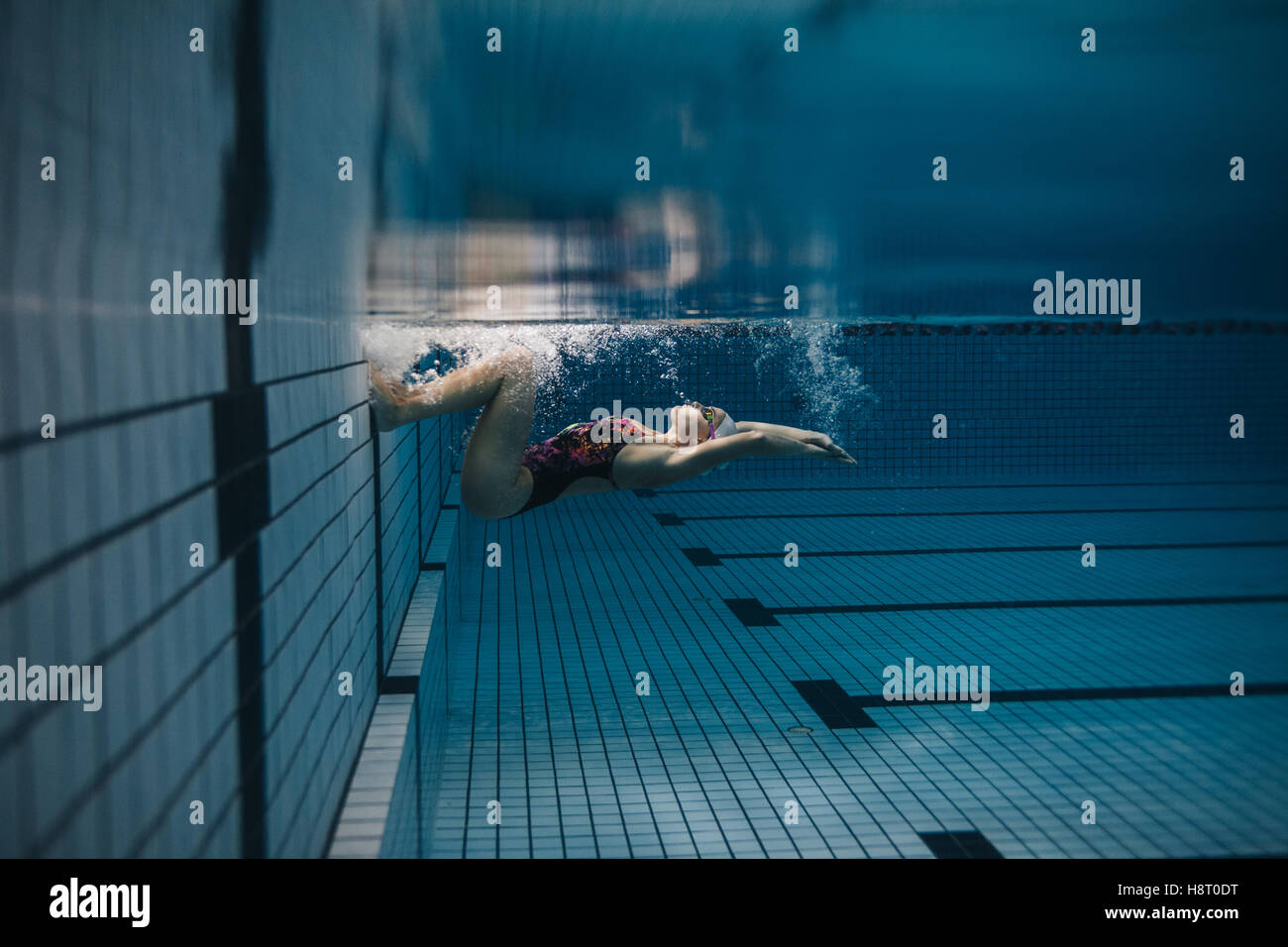 Schuss von Fit junge Frau umdrehen Unterwasser. Weibliche Schwimmer in Aktion im Schwimmbad. Stockfoto