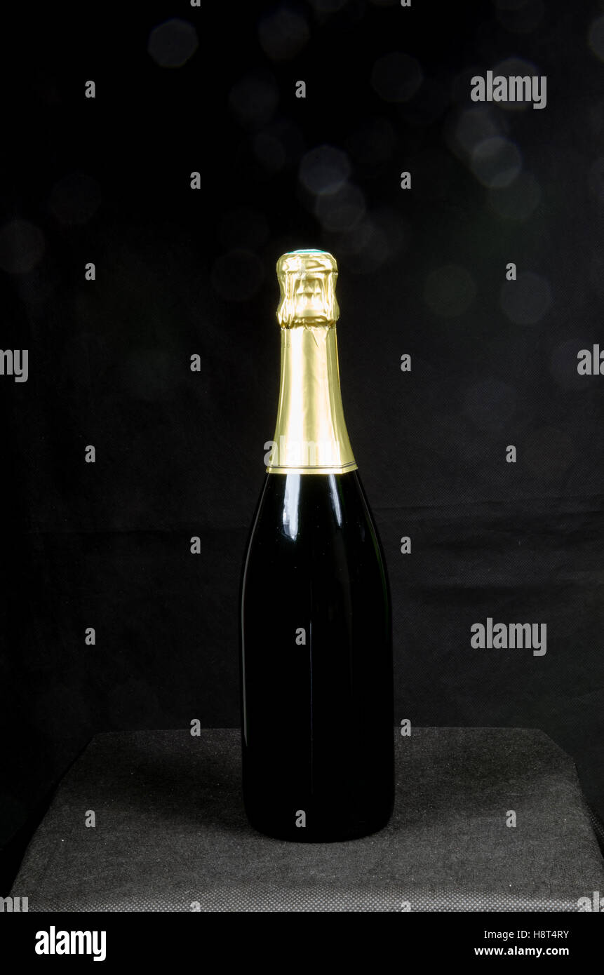 Einzelne Flasche Sekt mit einem schwarzen Hintergrund mit unscharfen bokeh Stockfoto