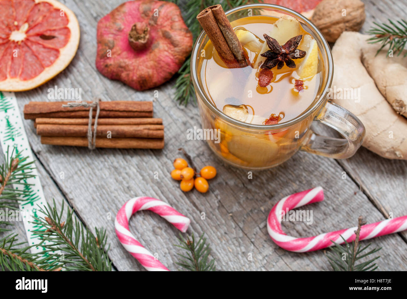 Weihnachten-Komposition. Fichte Zweige, Zuckerstange, Erwärmung Tee mit Ingwer und Zitrone, getrockneten Orangen, Grapefruit, Zimt, Stockfoto