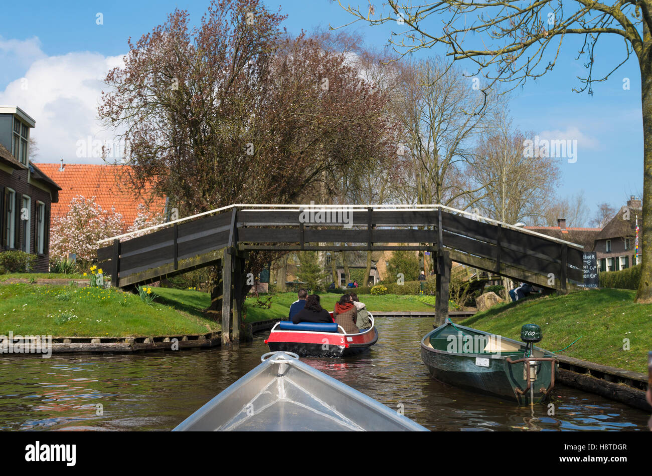 GIETHOORN, Niederlande - 3. April 2016: Unbekannte Menschen in Booten genießen ihre Sightseeing-Bootsfahrt in einem Kanal in Giethoorn, al Stockfoto