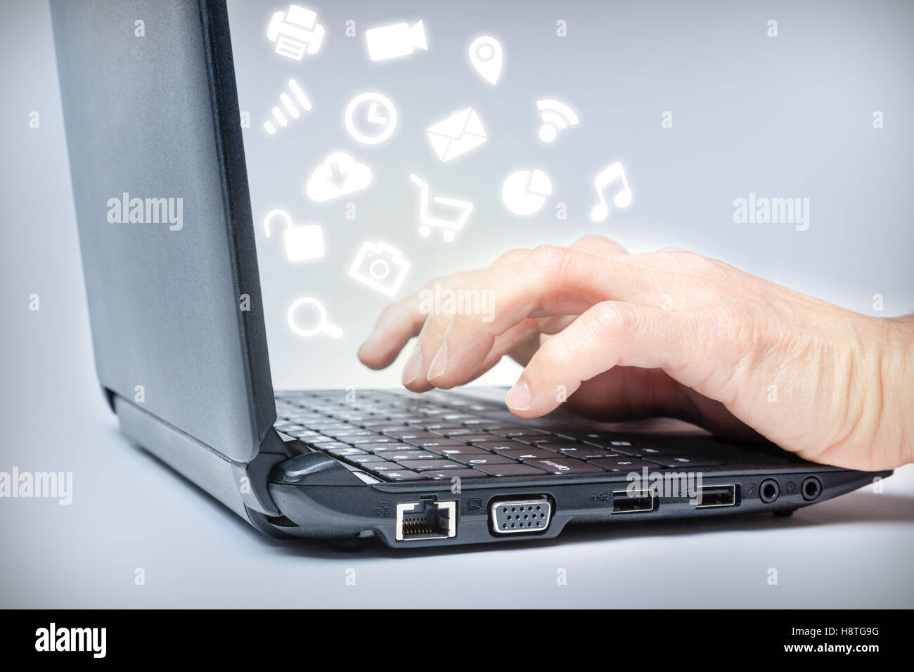 Hände, die Eingabe über Tastatur mit gemeinsamen Media-Icons von Laptop. Multi-tasking im Internet. Stockfoto