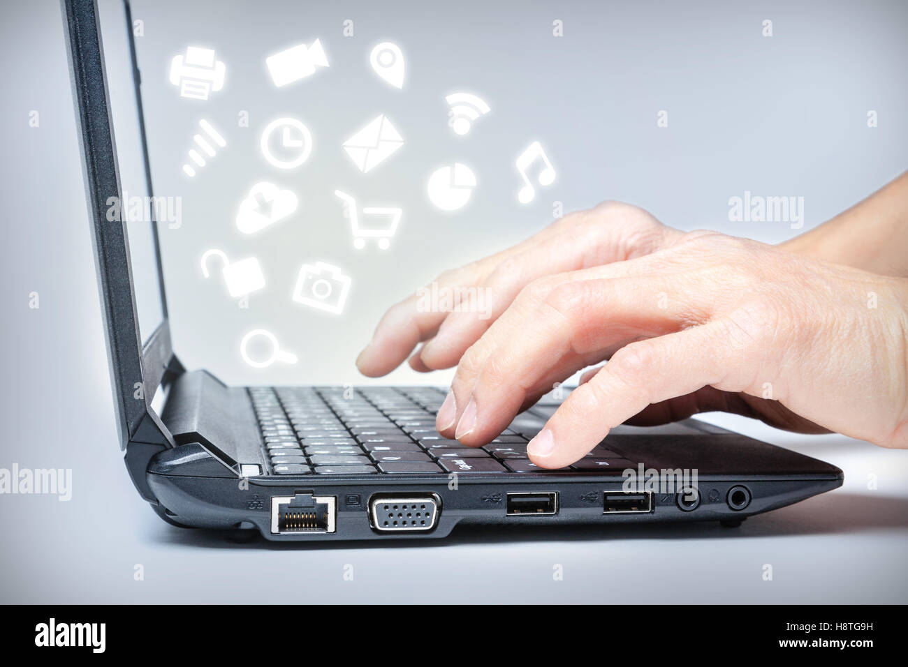 Hände, die Eingabe über Tastatur mit gemeinsamen Media-Icons von Laptop. Multi-tasking im Internet. Stockfoto