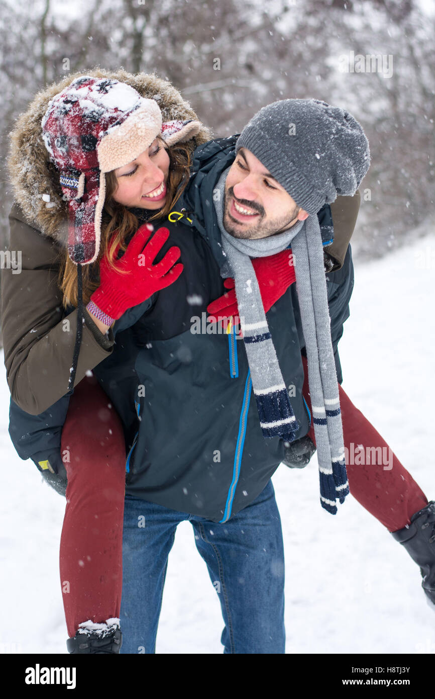 Paare, die Spaß in einem verschneiten park Stockfoto