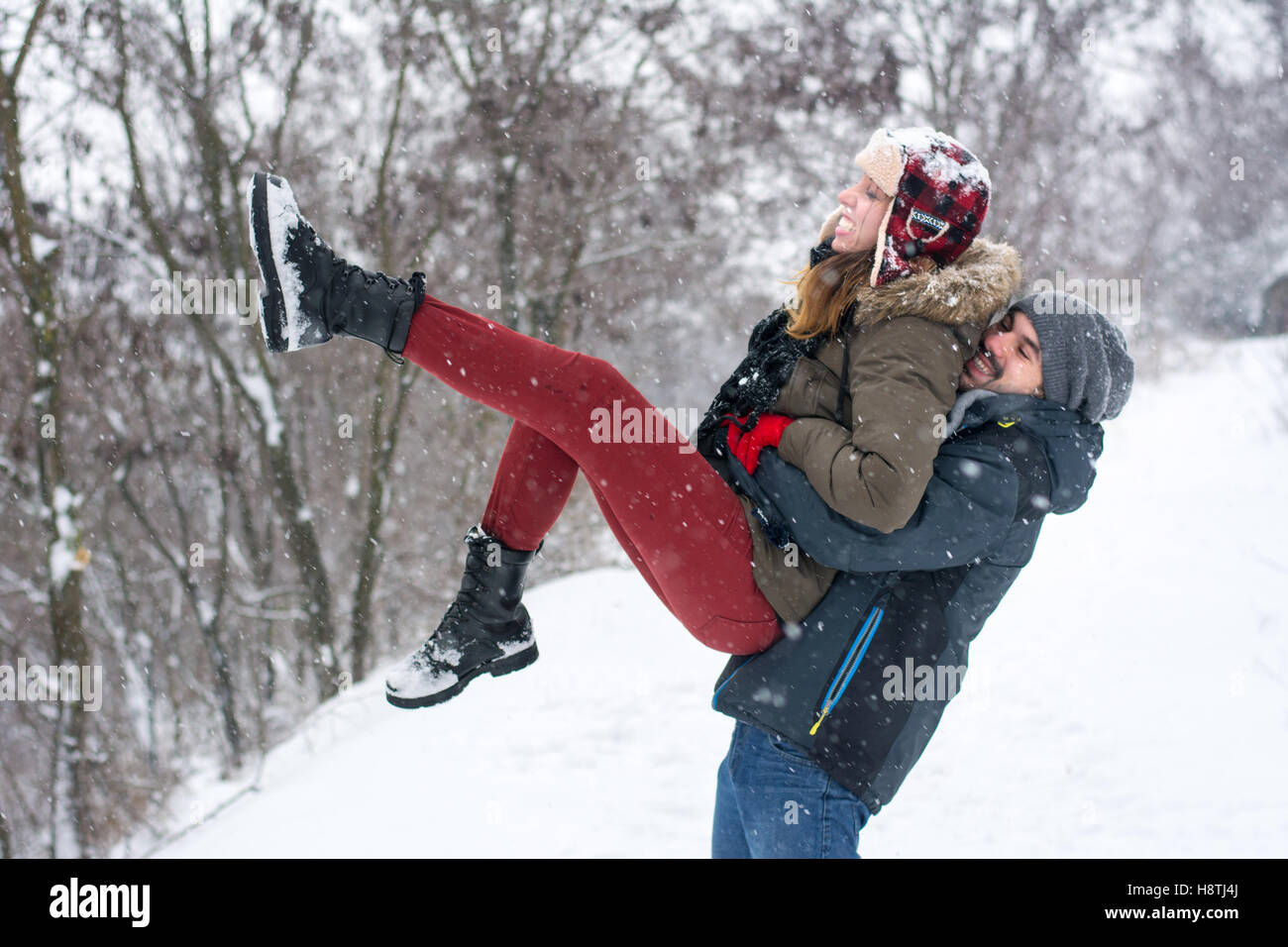 Paare, die Spaß in einem verschneiten park Stockfoto