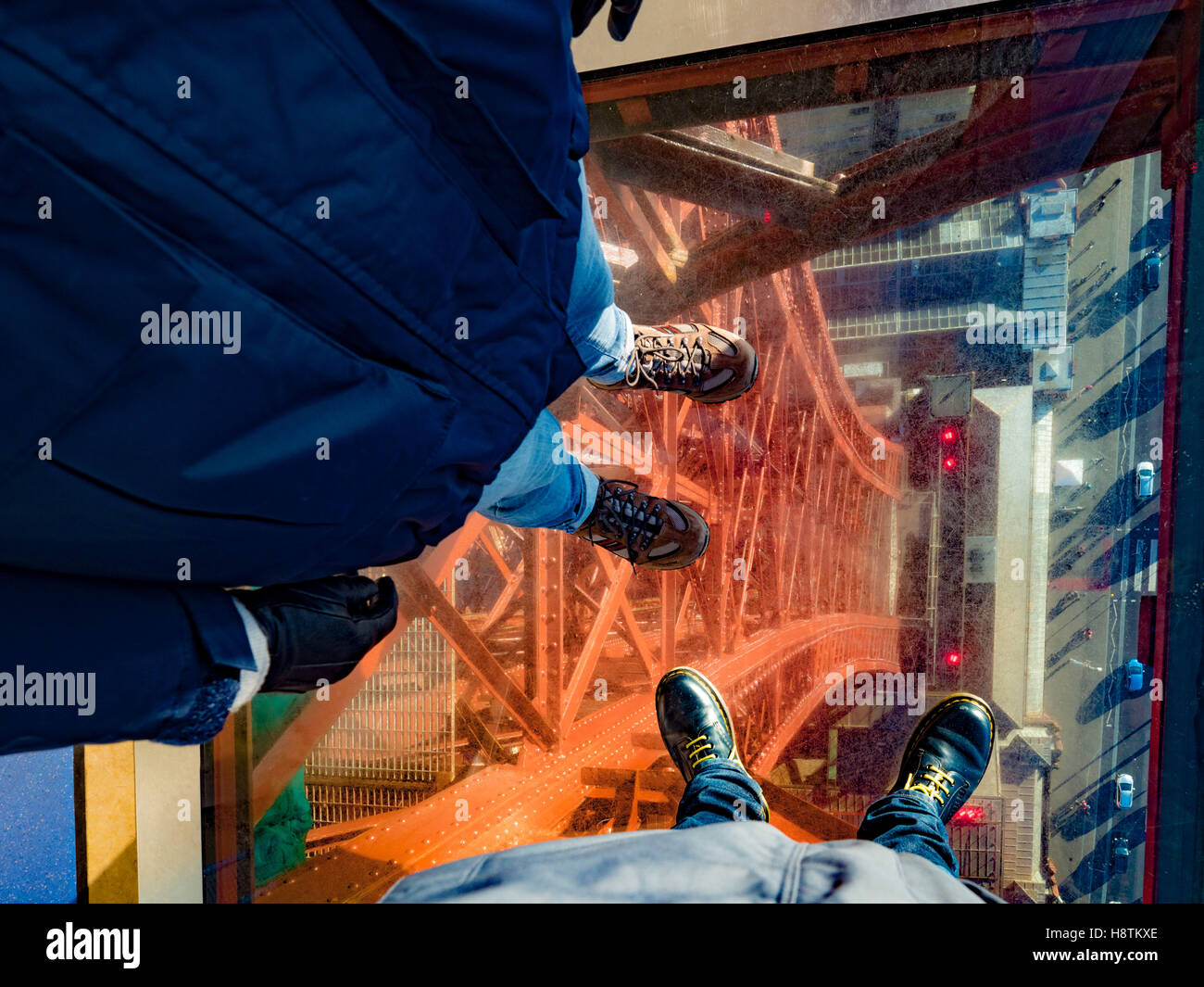 Zwei Paar Füße auf Glasboden des Blackpool Tower Skywalk, Lancashire, UK. Stockfoto