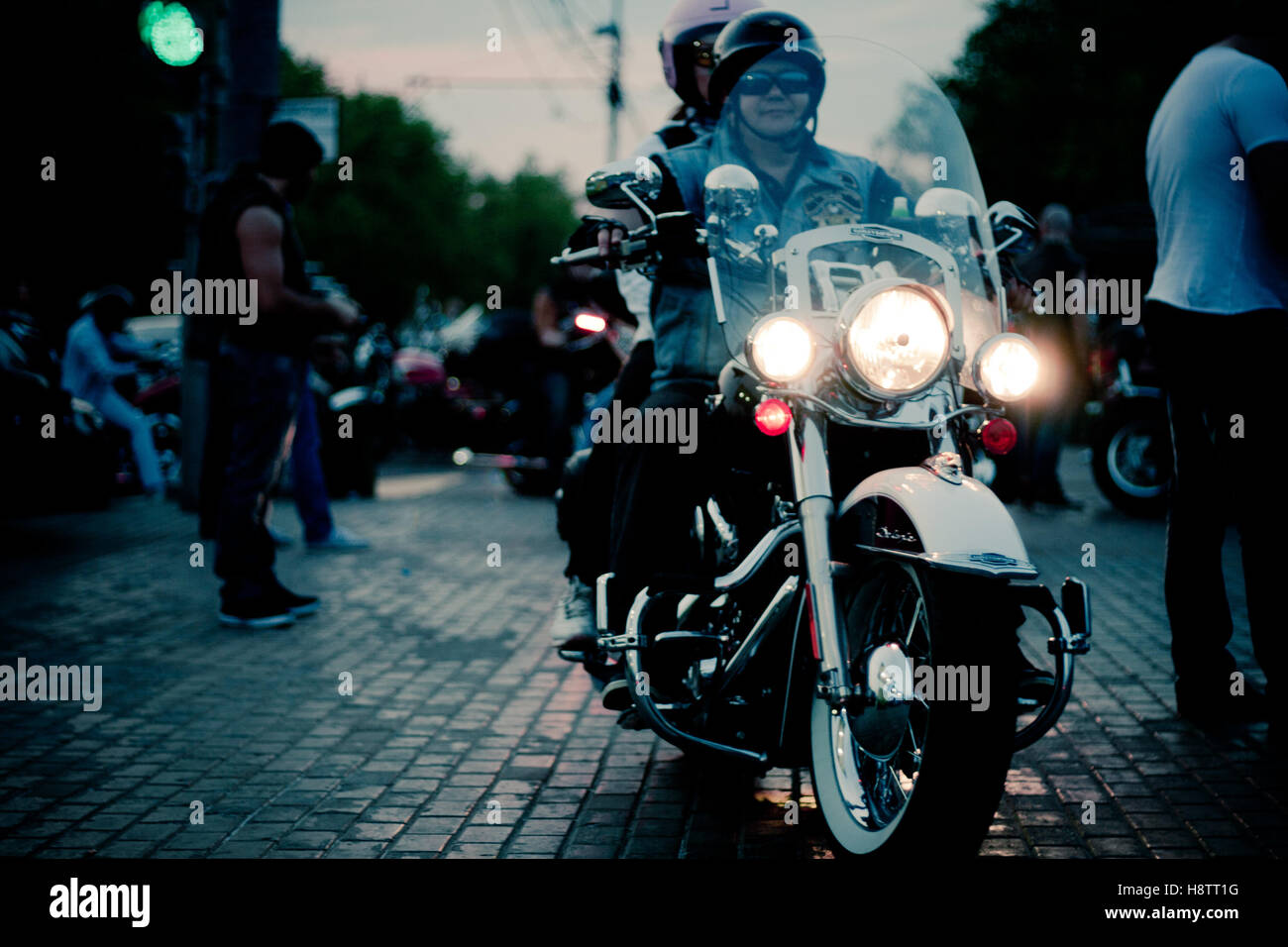 Moskau, Russland - 6. Oktober 2013: Eine Frau trägt einen Helm und Sonnenbrille auf einem weißen Harley-Davidson Motorrad mit einem beleuchteten h Stockfoto