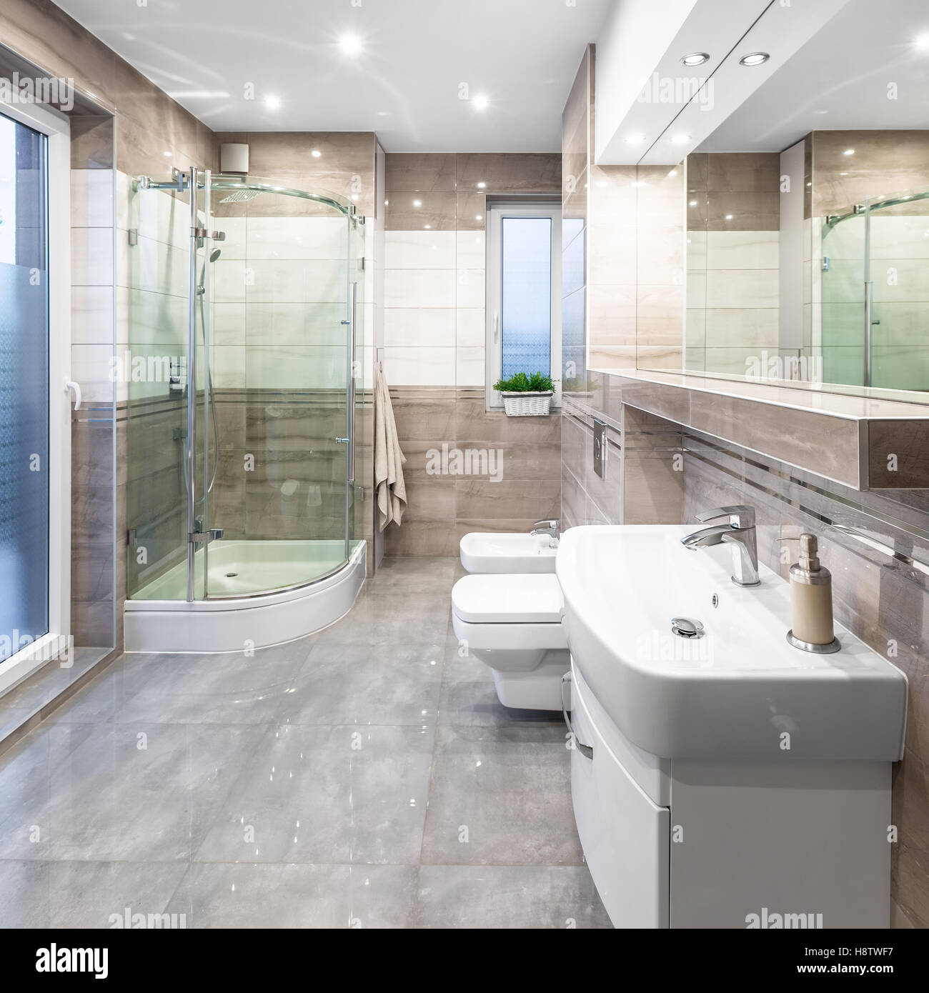 Geräumige Hochglanz Badezimmer mit Waschbecken, Spiegel, WC, Bidet und Dusche Stockfoto