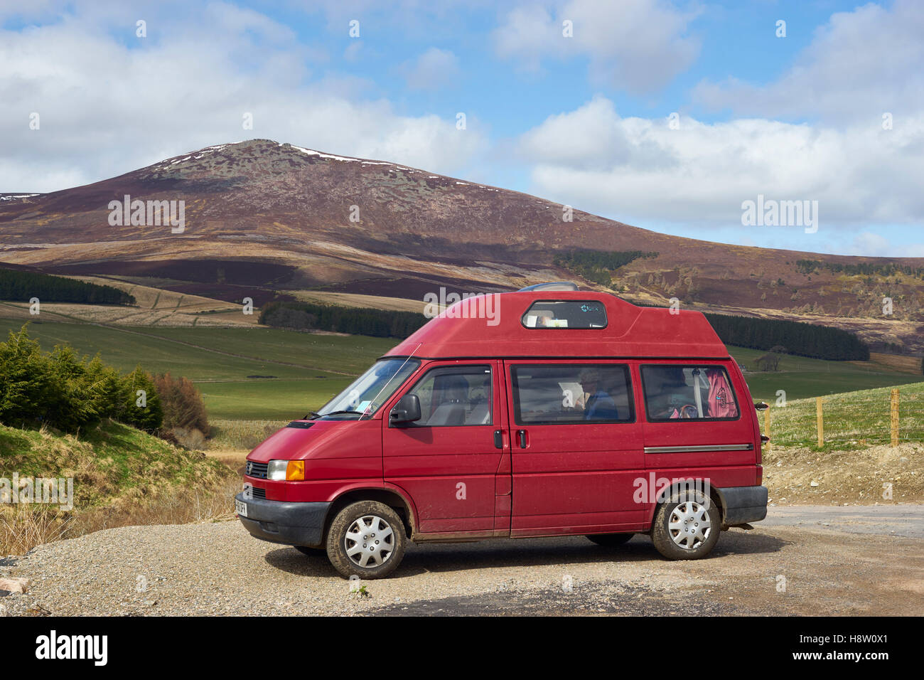 Roten VW T4 Leisuredrive Wohnmobil in Glenrinnes, mit Ben Rinnes hinter, Moray, Schottland Stockfoto