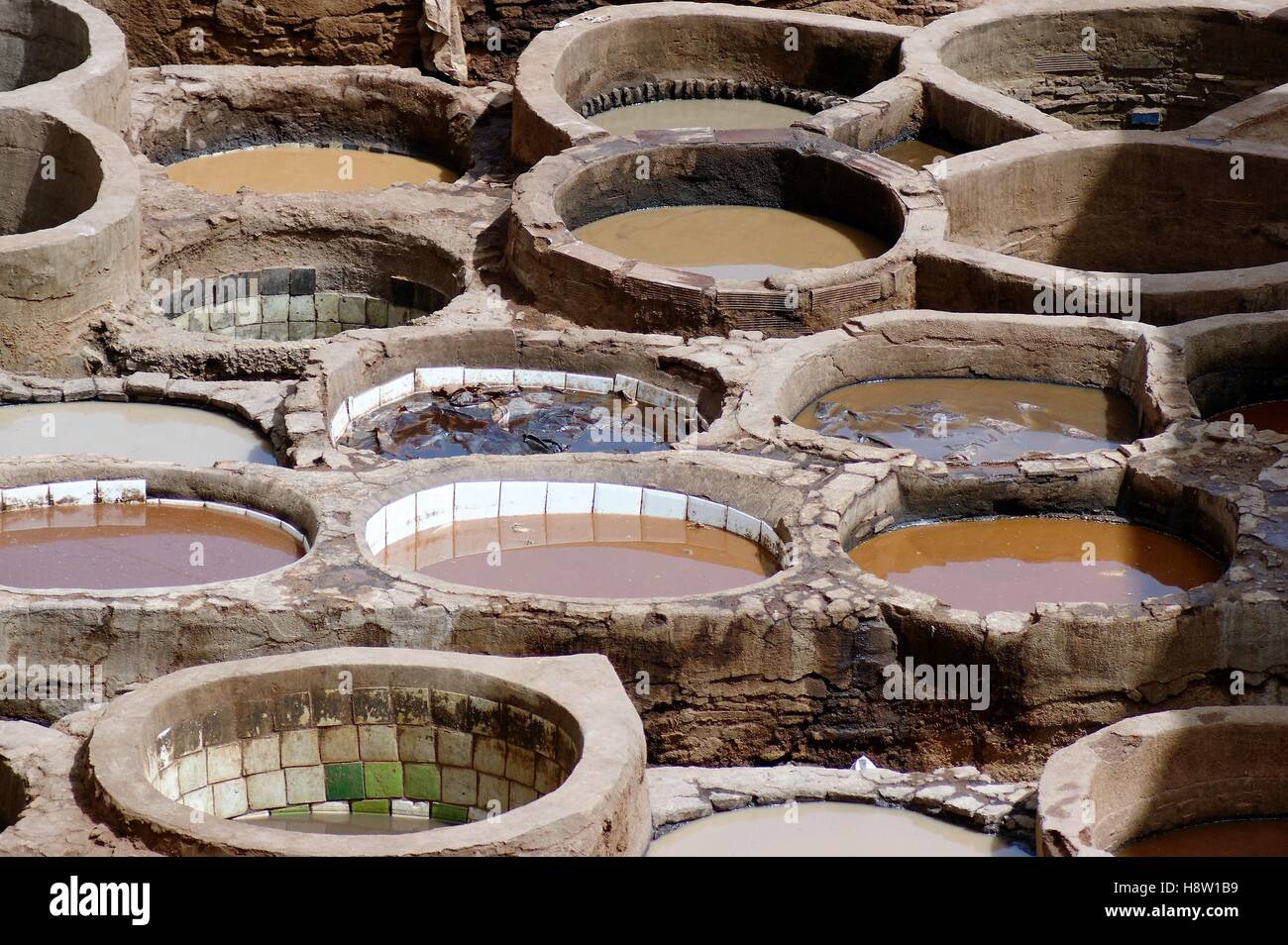 Die historische Ledergerberei Chouara, auch bekannt als Chouwara, in Fès, Marokko, nutzt runde, mit Stein geflieste Außenwände zum Färben der Textilien. Stockfoto