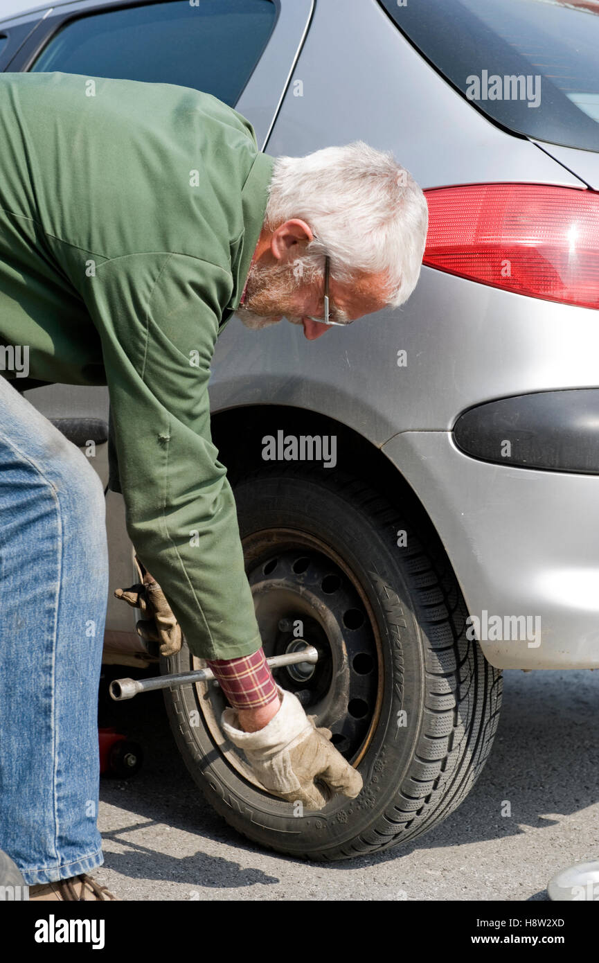Rentner, die Reifen wechseln Stockfoto