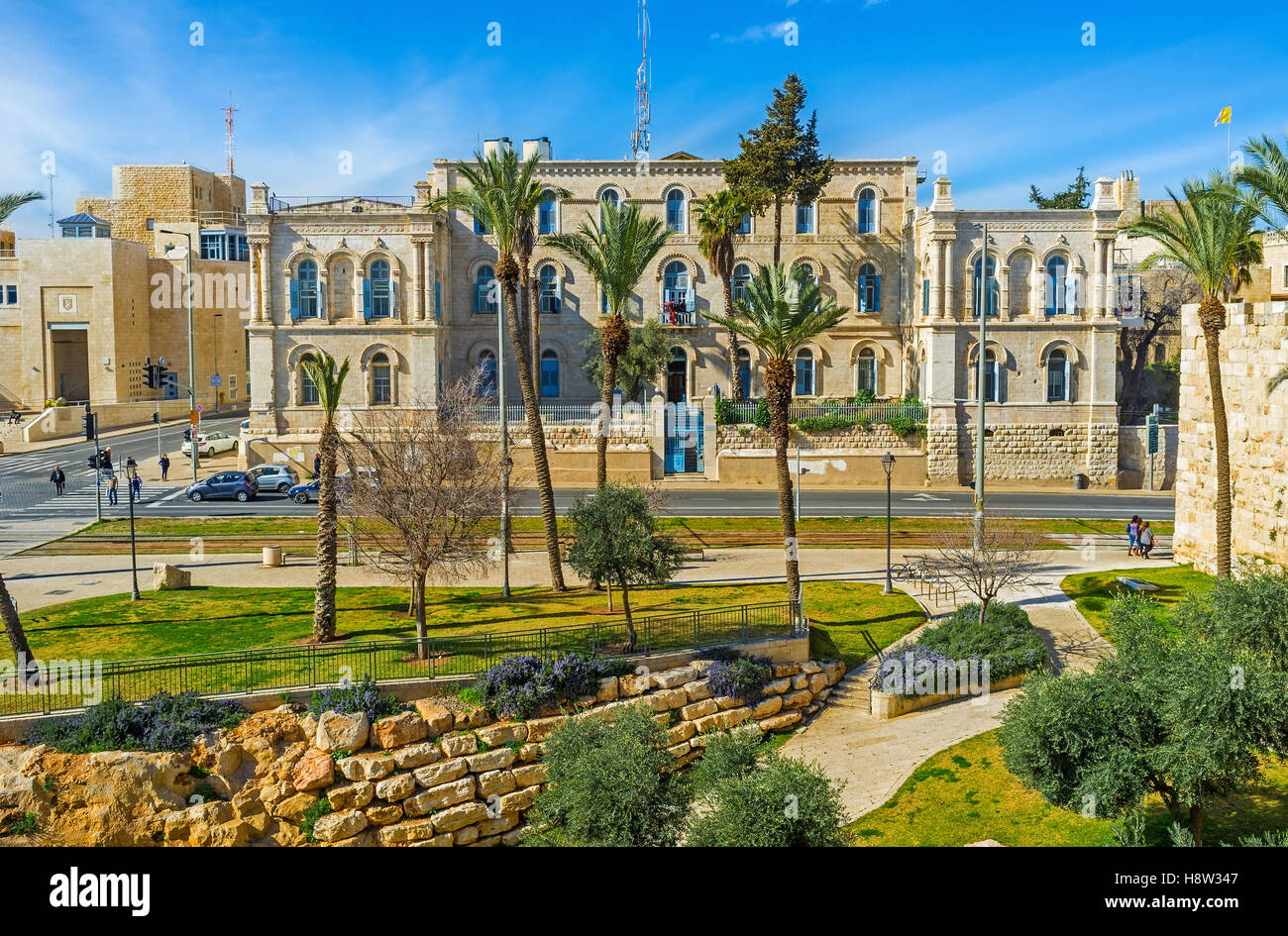 Das Gebäude des Krankenhauses St. Louis Französisch hinter den Palmen der Nationalgarten, Jerusalem, Israel. Stockfoto