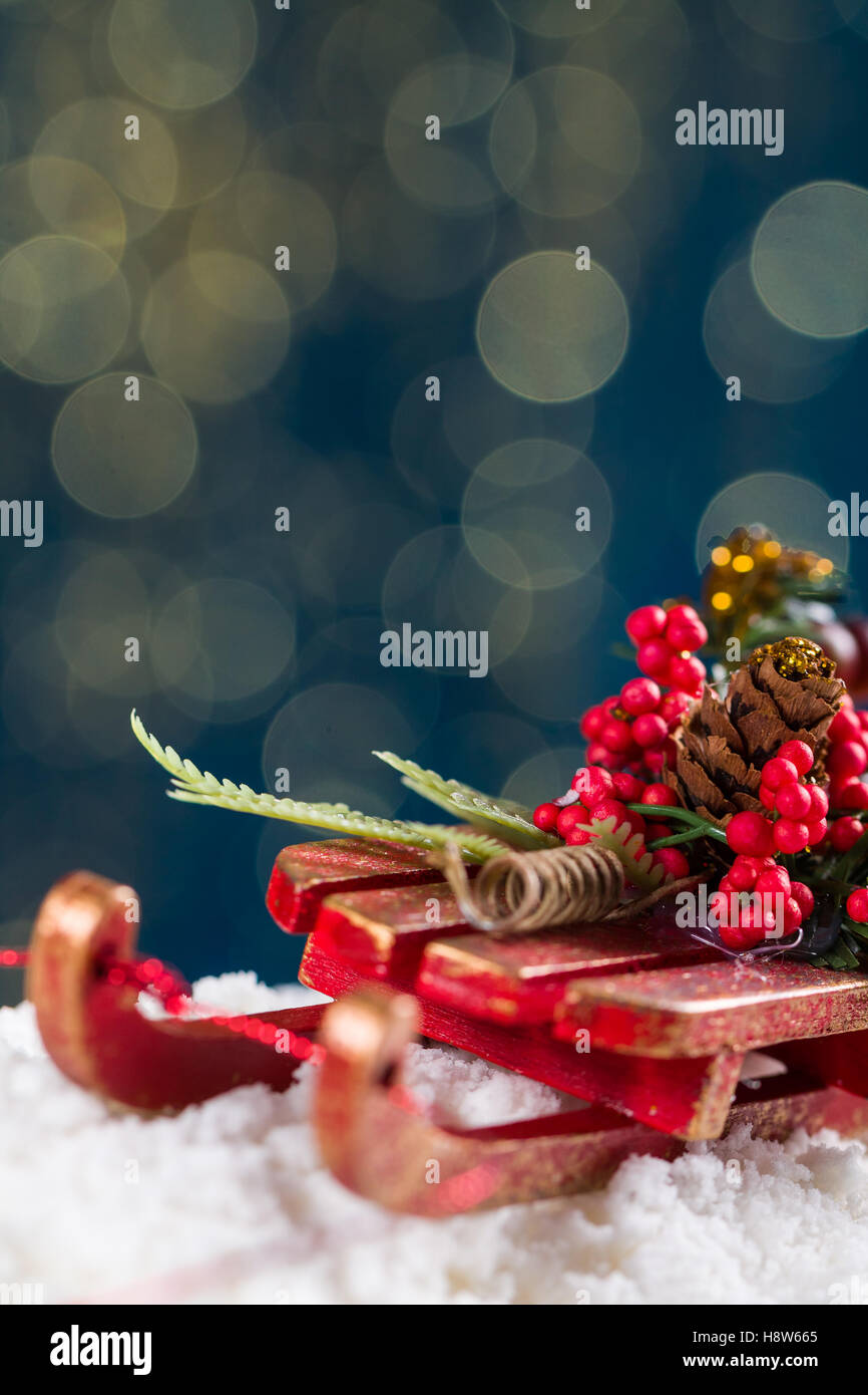 Dekorative Schlitten mit Roan- und Weihnachten Baum Zweige, fahren auf Schnee, im Hintergrund die schönen Bokech Kugeln. Stockfoto