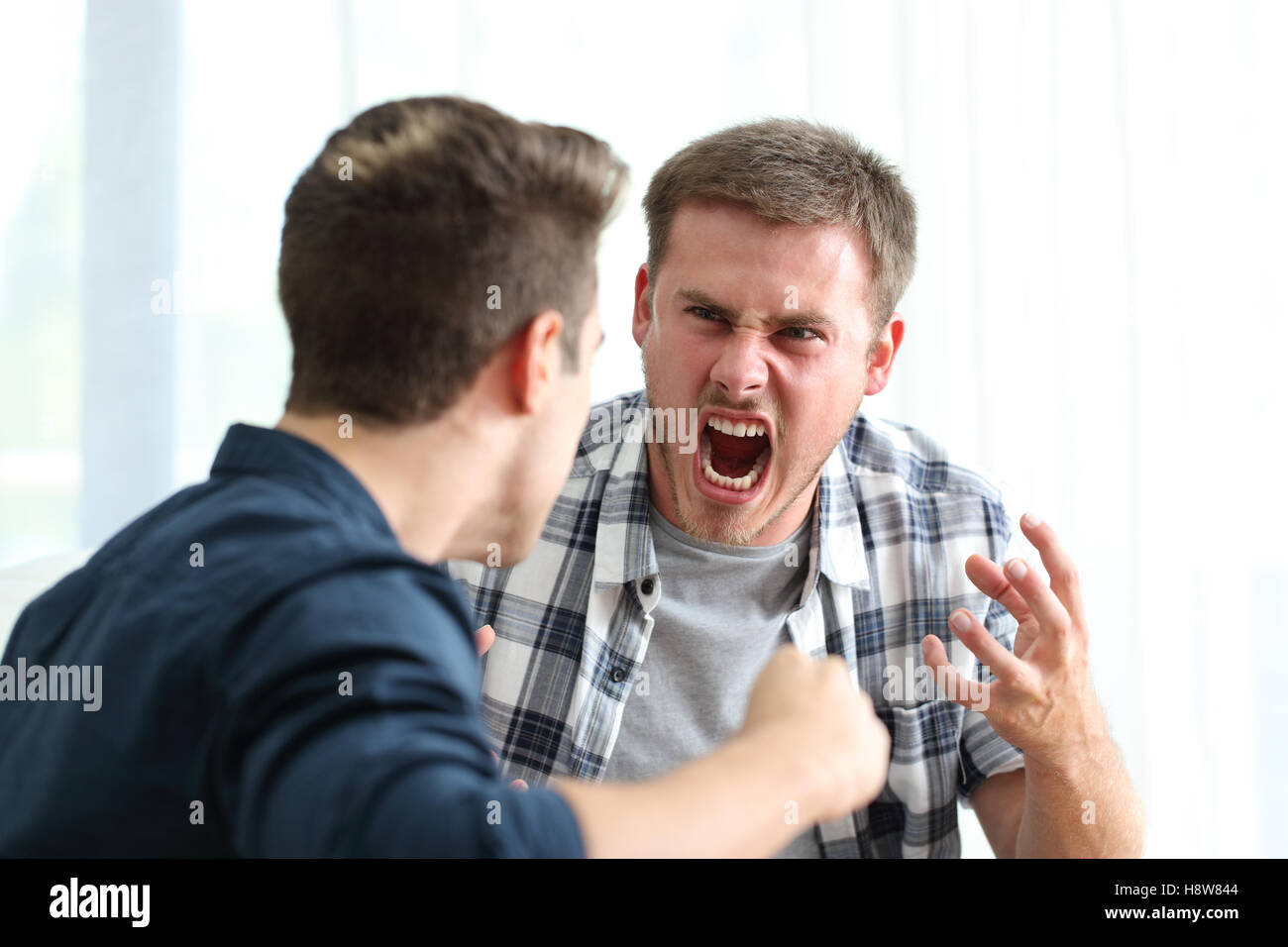 Zwei böse Freunde oder Mitbewohner streiten und droht in das Wohnzimmer zu Hause Stockfoto