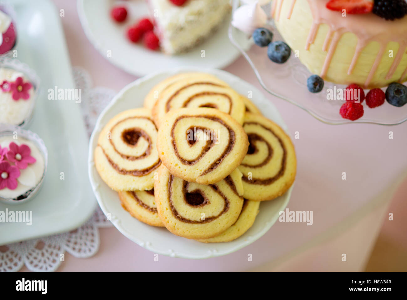 Spiral-Kekse, Kuchen und Muffins auf Tisch gelegt. Stockfoto