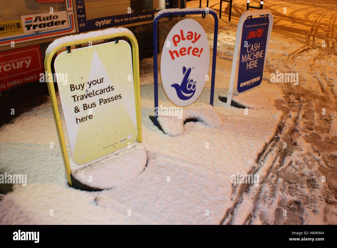 Geldautomat hier Lotto und Reisen Karte-Zeichen vor einem Geschäft mit Schnee bedeckt Stockfoto