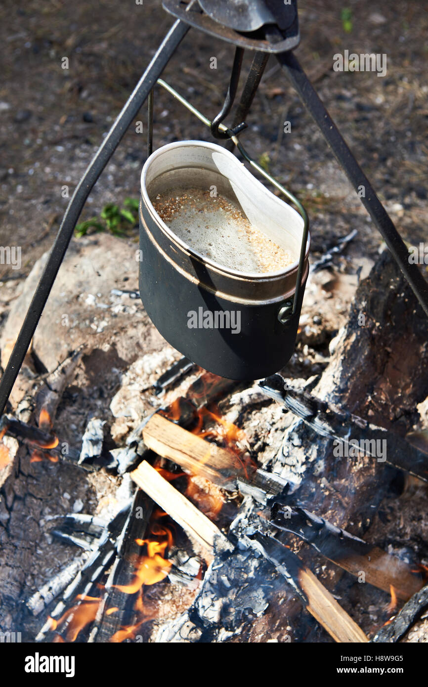 Essen wird über Lagerfeuer in Wanderung über die Fischerei in Topf zubereitet. Stockfoto