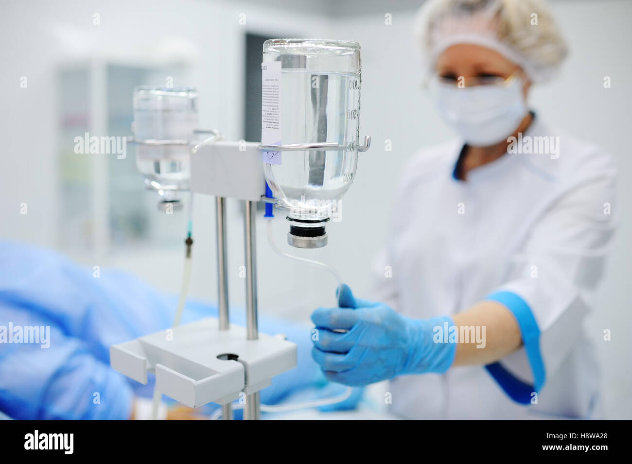 Krankenschwester stellt den Patienten medizinische Tropf in eine Vene auf dem Hintergrund des OP-Saal. Pipette vor dem Hintergrund des d Stockfoto