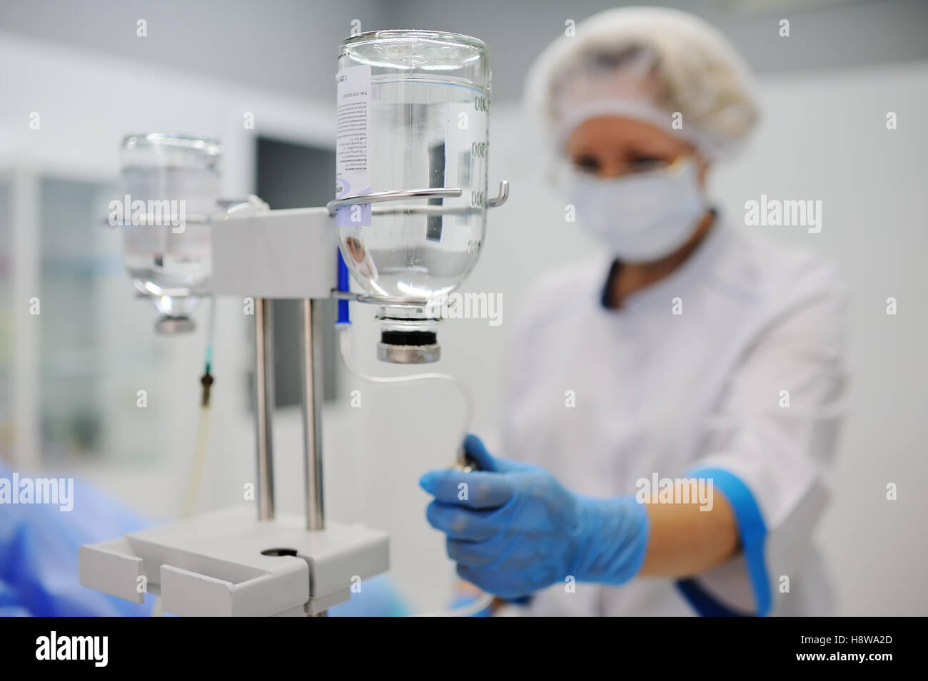 Krankenschwester stellt den Patienten medizinische Tropf in eine Vene auf dem Hintergrund des OP-Saal. Pipette vor dem Hintergrund des d Stockfoto