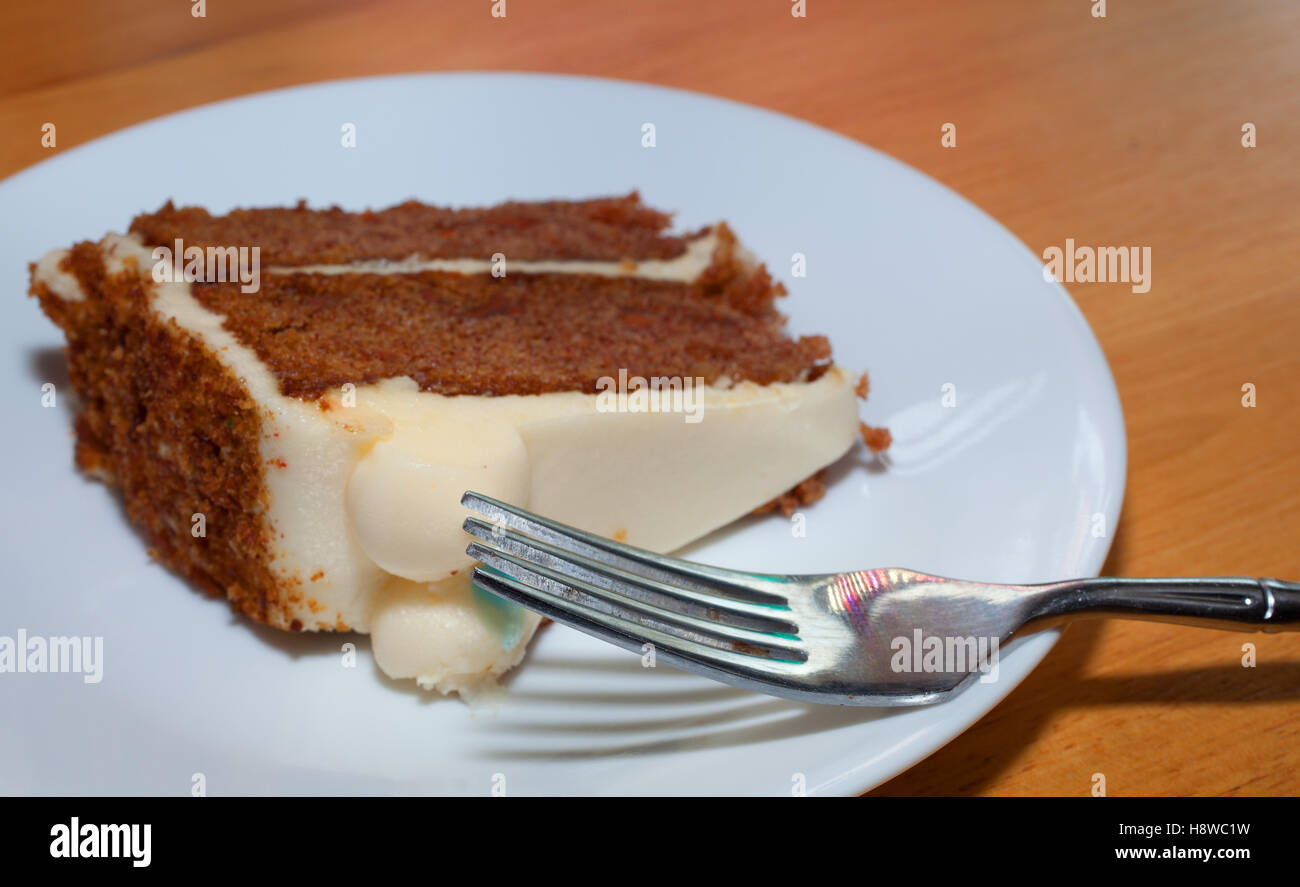Gabel auf einem Teller mit einer Scheibe Karottenkuchen Stockfoto