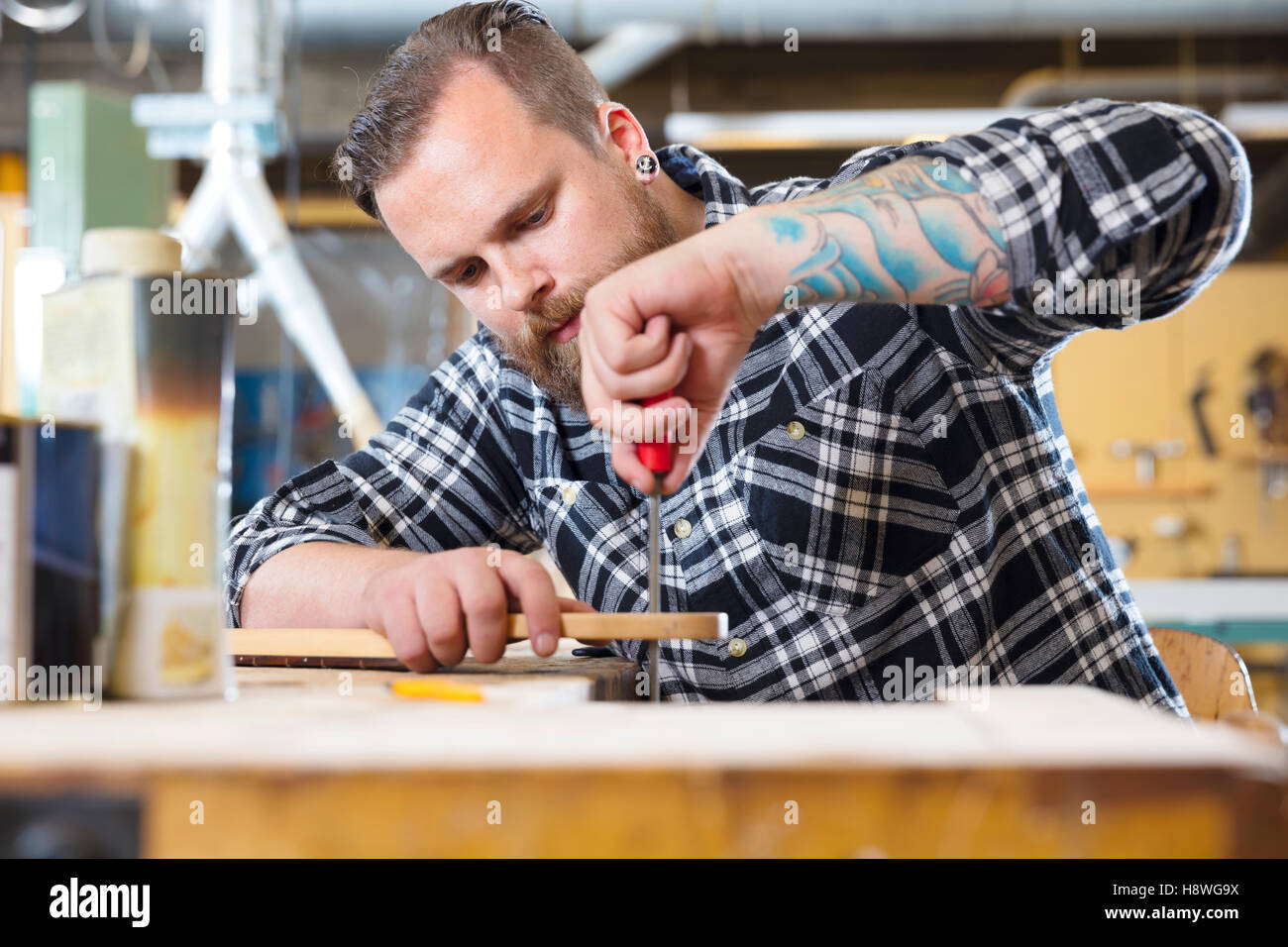 Handwerker-Dateien aus Holz Gitarrenhals in Werkstatt Stockfoto