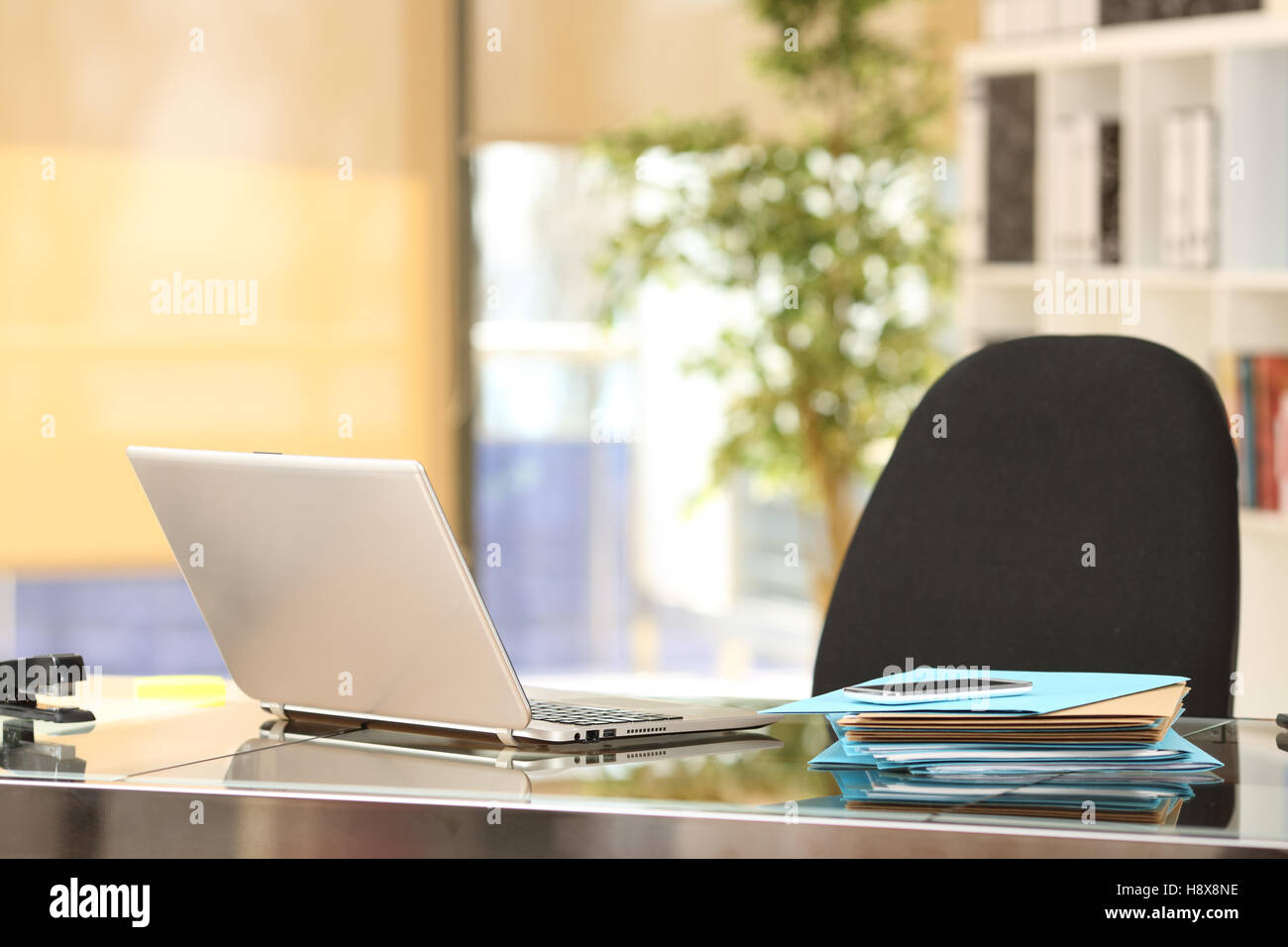 Desktop in einen Büroarbeitsplatz mit Laptop, Handy und Dokumente Stockfoto