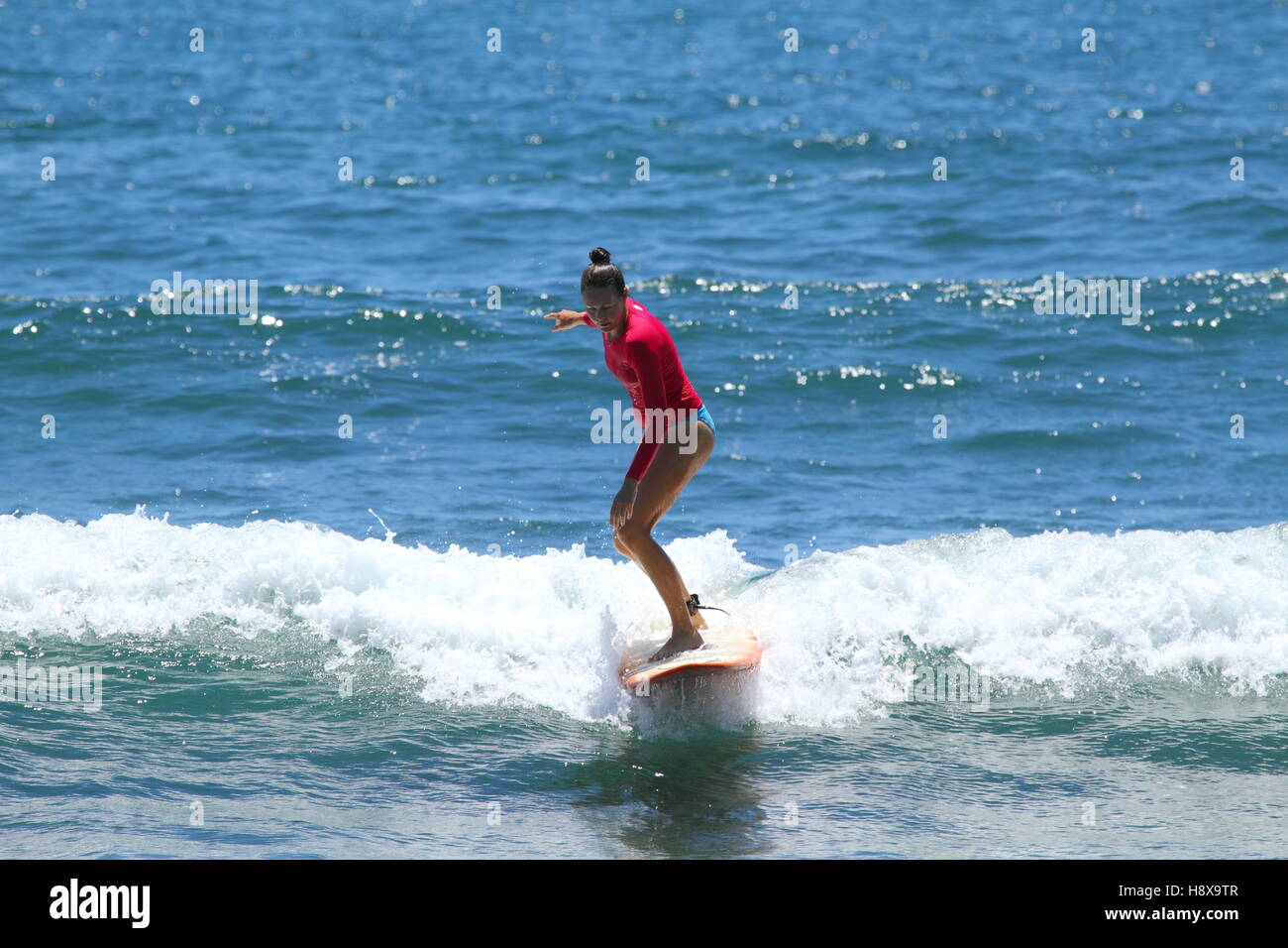 Eine Frau in ihren Dreißigern Surfen eine Longboard in Moffat Beach an der Sunshine Coast in Queensland, Australien. Stockfoto