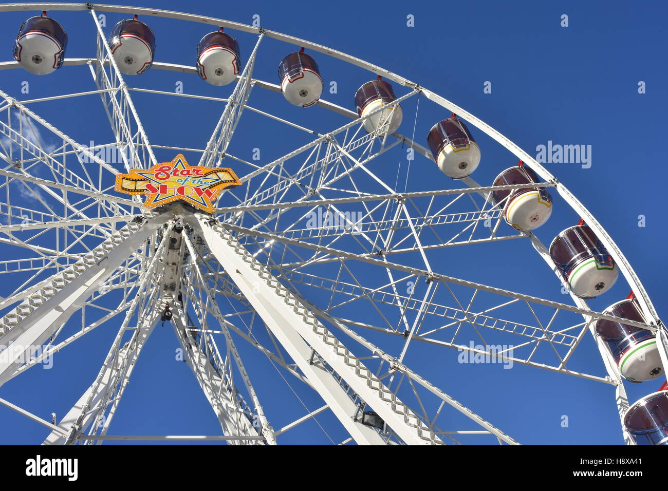 niedrigen Winkel Schuss ein kleines Riesenrad vor einem blauen Himmelshintergrund Stockfoto