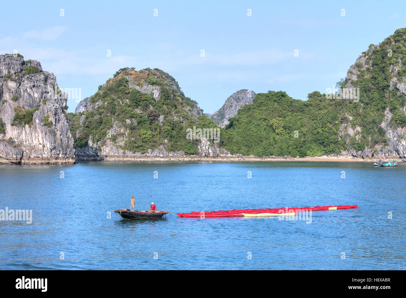Vietnamesische Fischer unter Kajaks für Touristen in Halong Bucht, Vietnam, Indochina, Asien Stockfoto