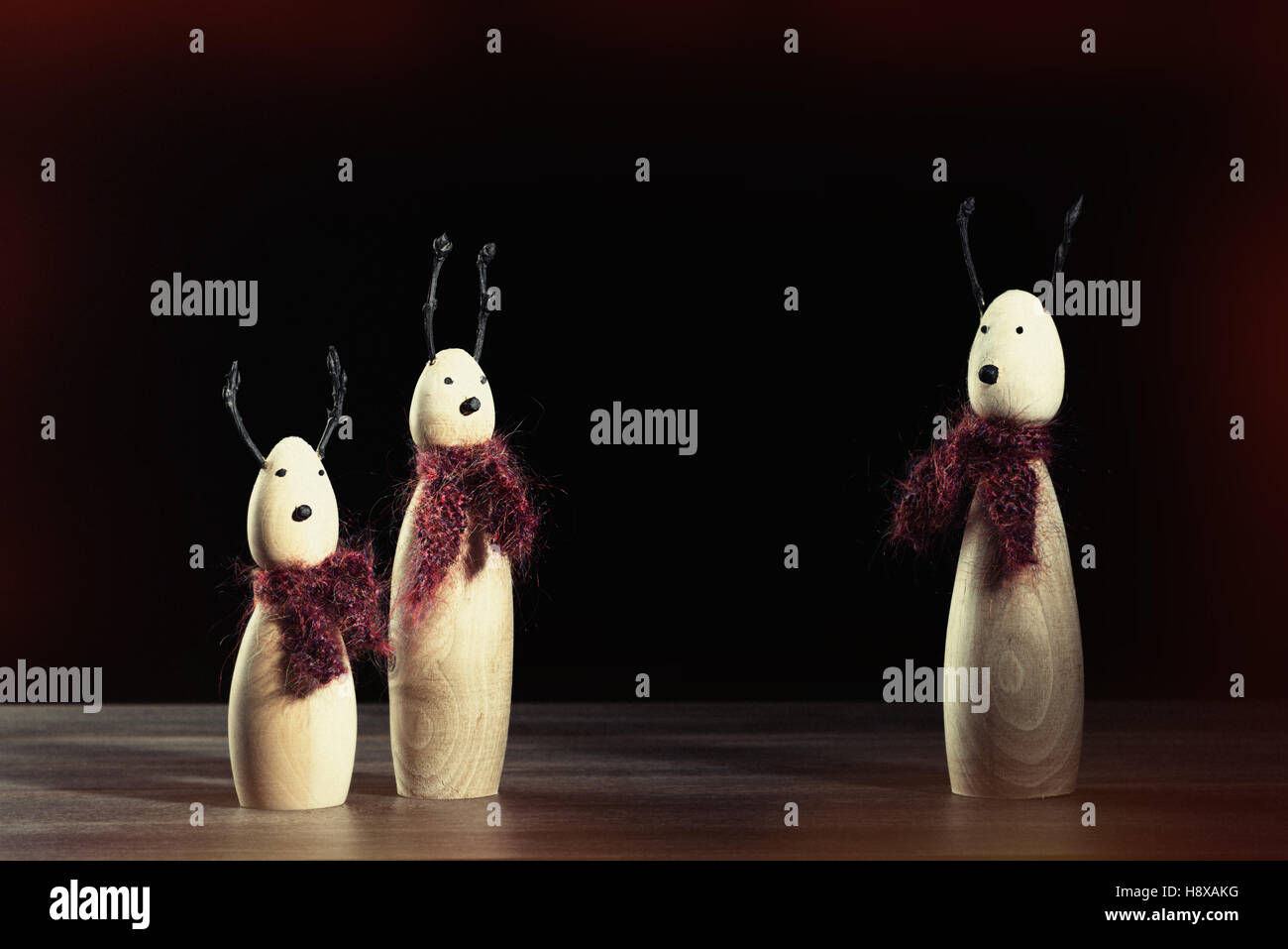 Kleine hölzerne Rentiere Ornamente tragen Strickschals Stockfoto