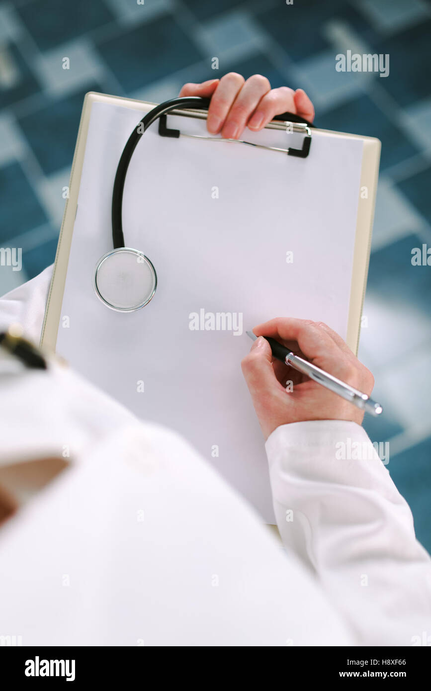 Ärztin in weißen Uniform schreiben auf Papier Zwischenablage als textfreiraum für medizinische Vorgeschichte des Patienten. Frau als Spezialist für Gesundheit Prüfung, äh, Krankheit Stockfoto