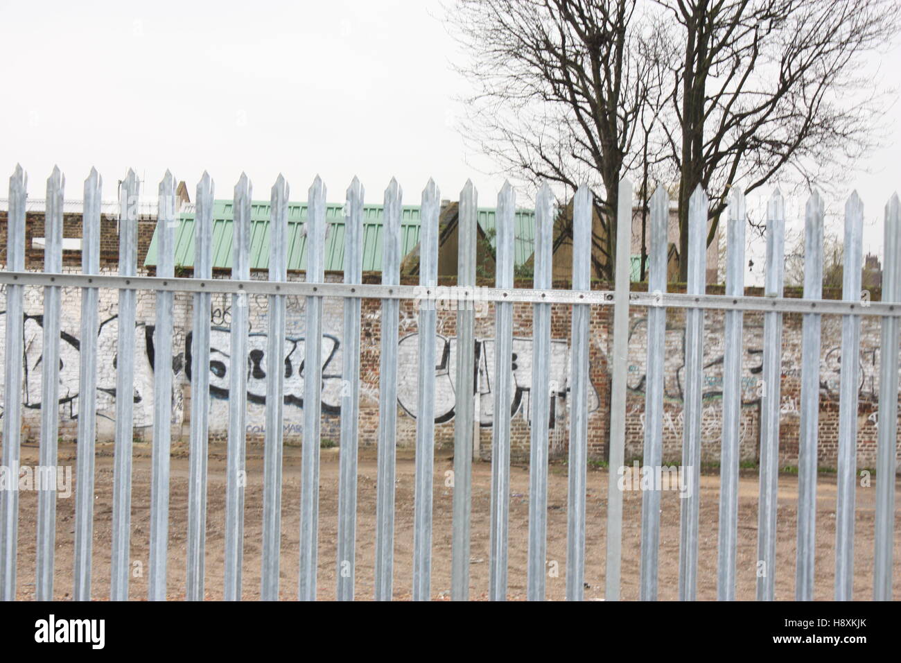 Silber Stahl verzinkter Zaun und Graffiti-Wand-Hintergrund in New Cross - South East London wies Stockfoto