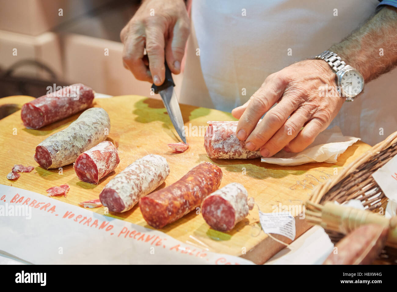 Mann schneiden gewürzte Salami auf Verkauf während Alba weiß Trüffelmesse in Alba, Italien Stockfoto