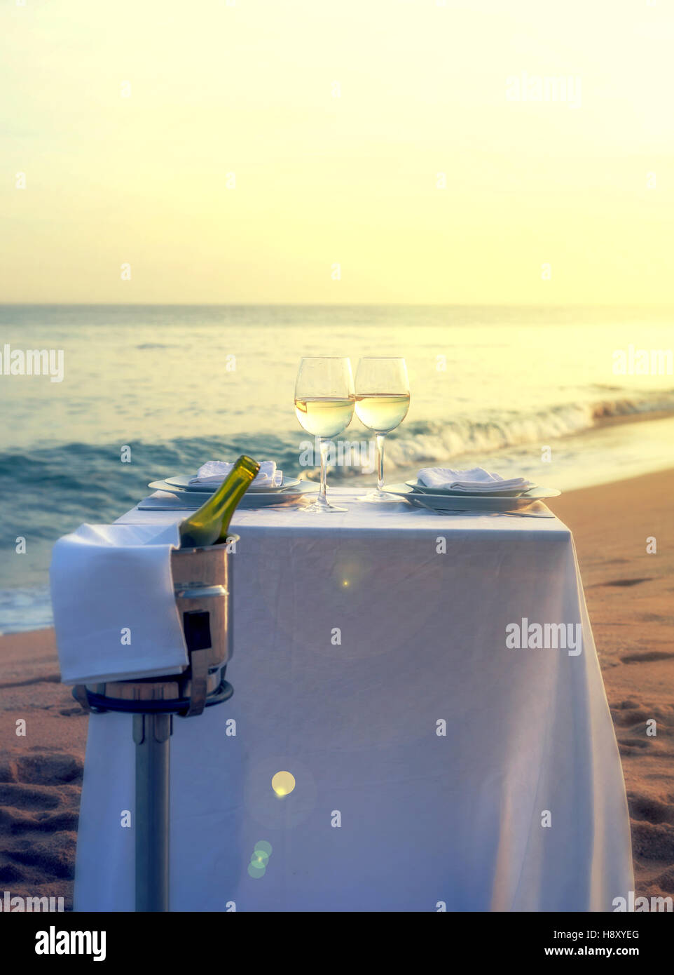 Ein romantisches Restauranttisch am Strand an einem Sommerabend. Stockfoto