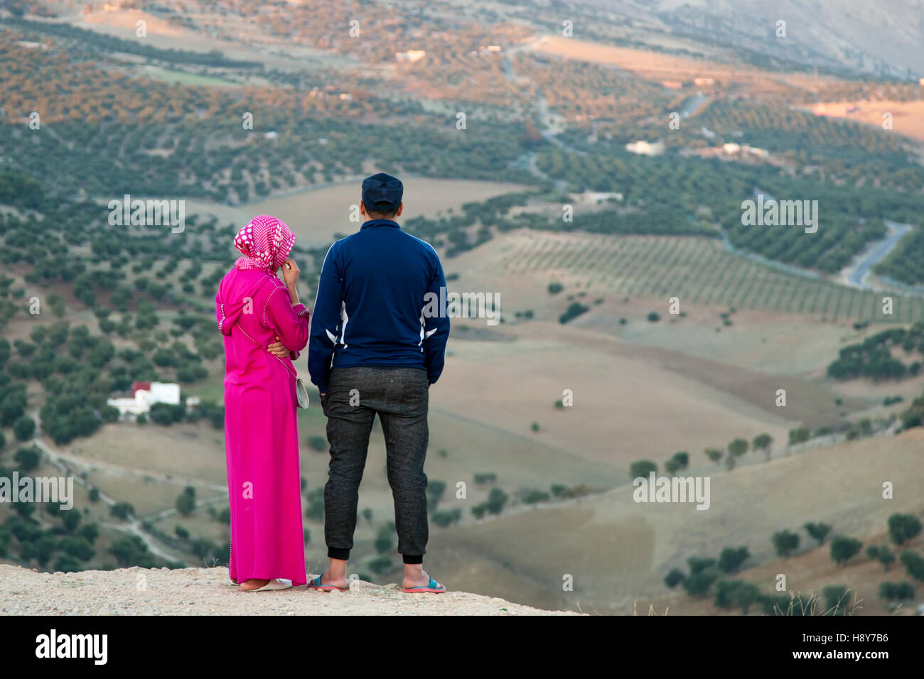 Junge muslimische Paar auf einem Hügel in der Nähe von Fès, mit Blick auf Landschaft Panorama mit Olivenbäumen Stockfoto