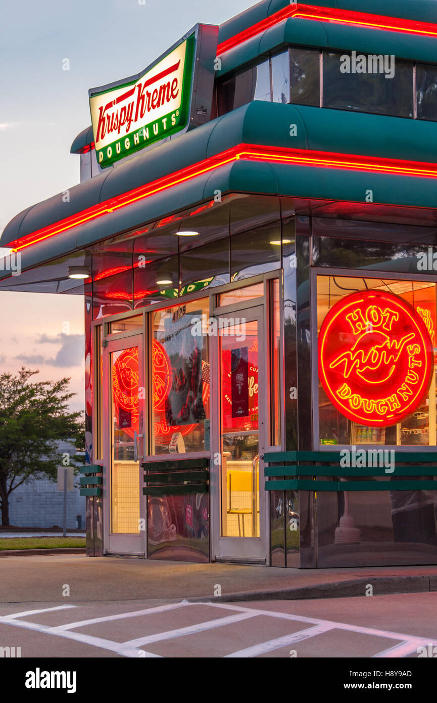 Krispy Kreme Doughnuts Shop erstrahlt in der Abenddämmerung in der Nähe von Atlanta, Georgia, USA. Stockfoto