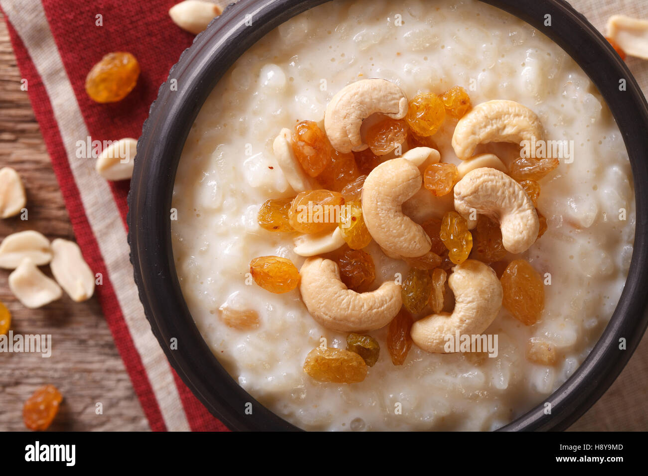 süße Milchreis mit Nüssen und Rosinen in eine Schüssel Nahaufnahme auf dem Tisch. Horizontale Ansicht von oben Stockfoto