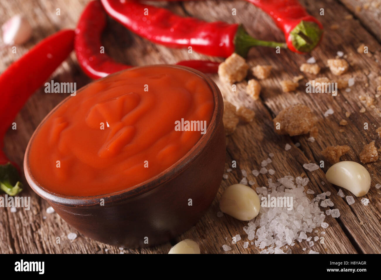 Rote Chilisauce Sriracha mit Zutaten auf den Tisch. horizontal, Makro Stockfoto