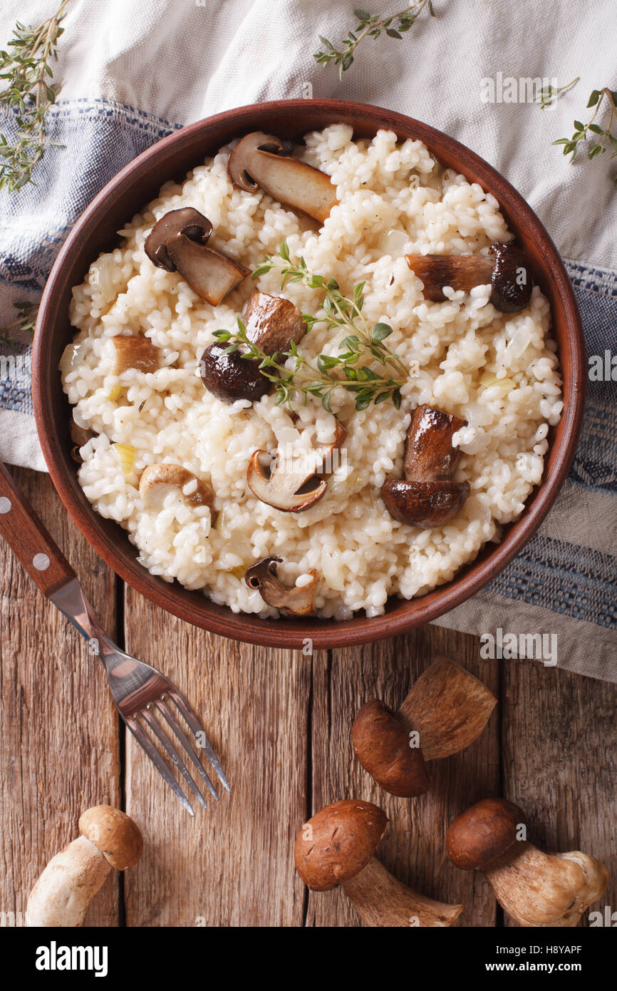 Risotto mit Steinpilzen und Thymian-close-up auf dem Teller. Vertikale Ansicht von oben Stockfoto