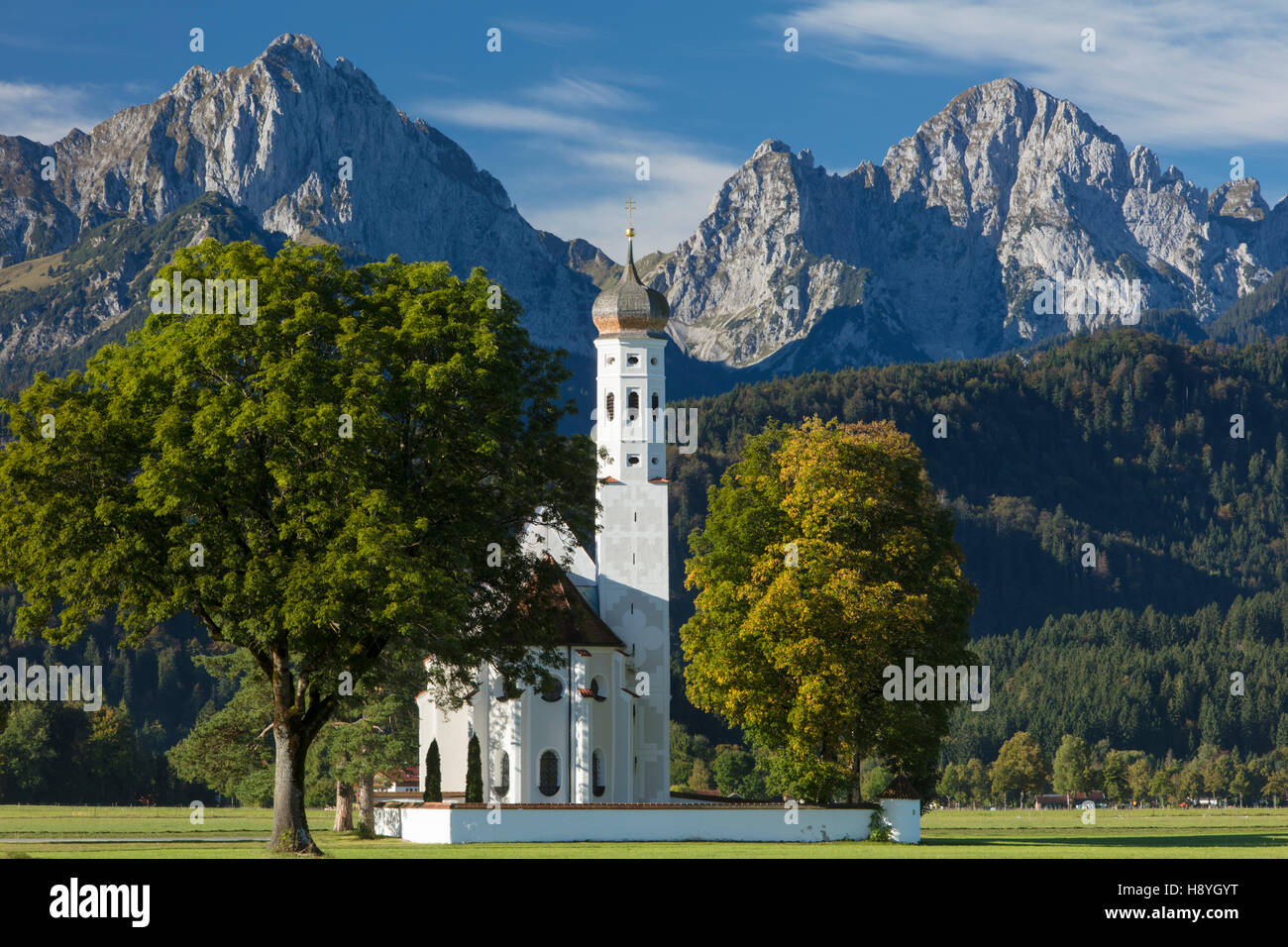 Bayerische Alpen tower über der Pilgernden Kirche St. Coloman, Schwangau, Bayern, Deutschland Stockfoto