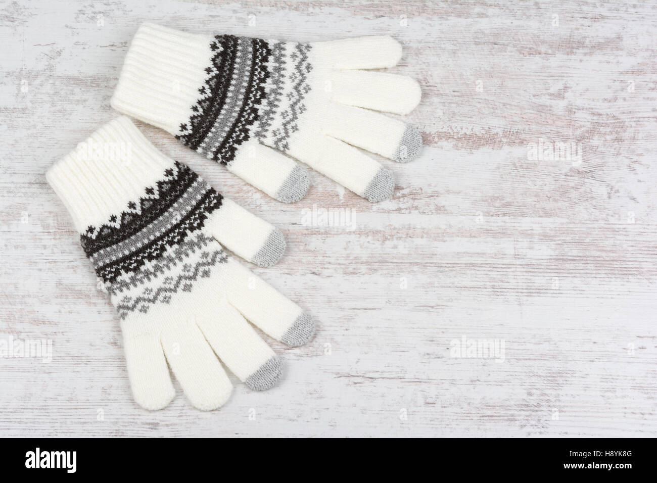 Ein paar Winter gestrickte Handschuhe auf weißem Holz Hintergrund Stockfoto
