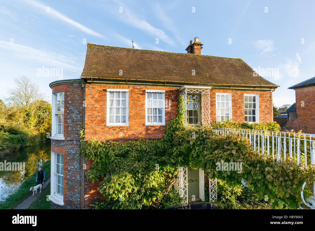 Am Straßenrand auf eine ungewöhnliche im georgianischen Stil erbaute Haus am Fluss Dun zugegriffen durch einen Kriechgang Covered Bridge in Newbury, Berkshire, Südengland Stockfoto