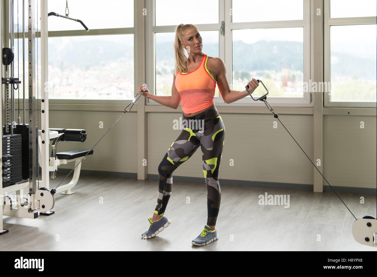 Gesunde Fitness Frau schwere Übung für Bizeps Maschine In der Turnhalle Stockfoto